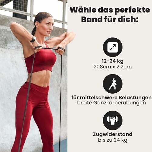 Frau trainiert mit Widerstandsband in rotem Sportoutfit.