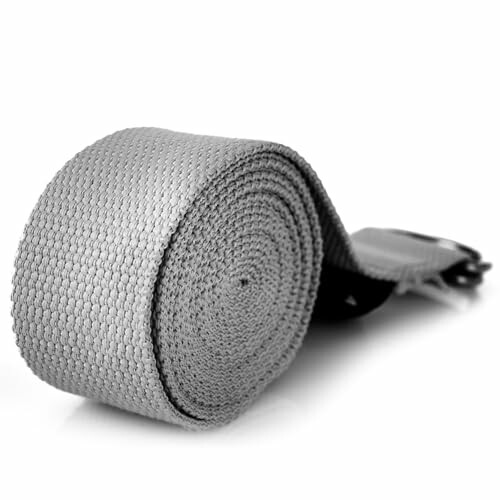 Grauer Yoga-Gurt aufgerollt auf weißem Hintergrund.